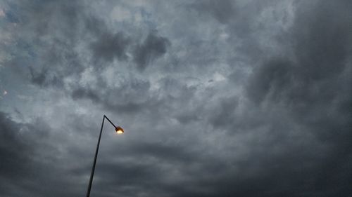 Low angle view of street light against cloudy sky