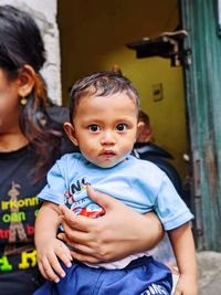 Portrait of smiling mother carrying daughter