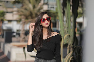 Young woman wearing sunglasses standing outdoors