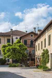 Street by buildings in town against sky