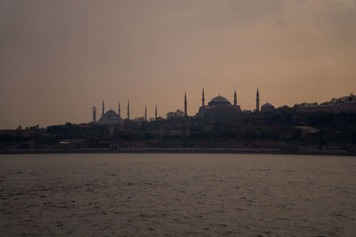 View of mosque against buildings at sunset