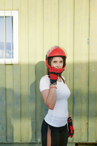 Young fit female posing with a red helmet and red gloves