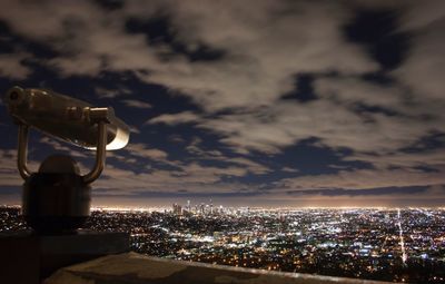 Illuminated cityscape against sky at night