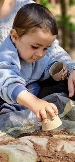 High angle view of boy playing with clay pots