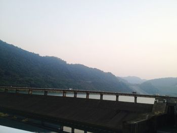 Bridge over mountains against clear sky