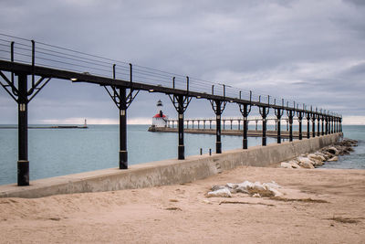 Suspension bridge over sea against sky