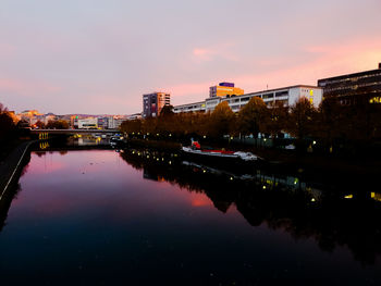 Bridge over river in city against sky during sunset
