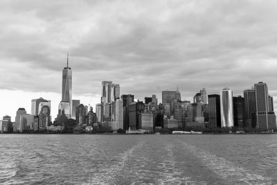 Modern buildings in city against cloudy sky