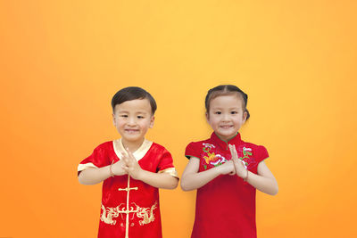 Portrait of a smiling girl against yellow background