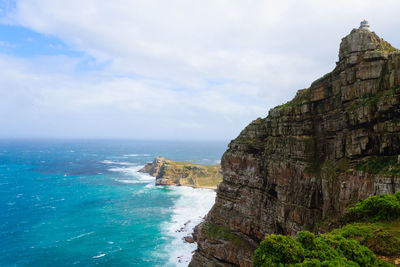 Rock formations by sea against sky