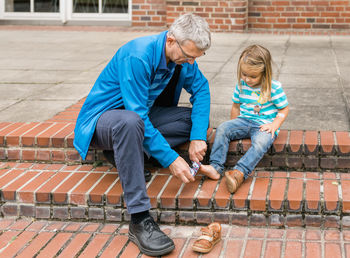 Rear view of father and daughter sitting on seat