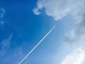 Low angle view of vapor trail against blue sky
