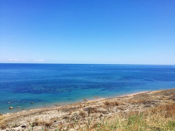 Scenic view of sea against clear blue sky
