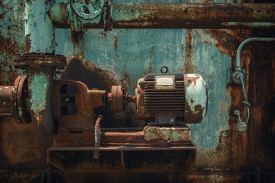 Close-up of old machinery against wall in room