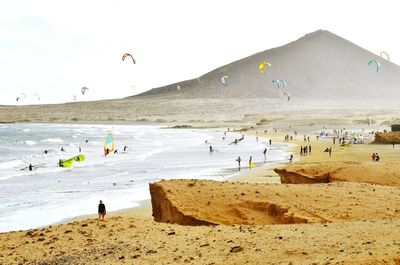 People at beach against sky