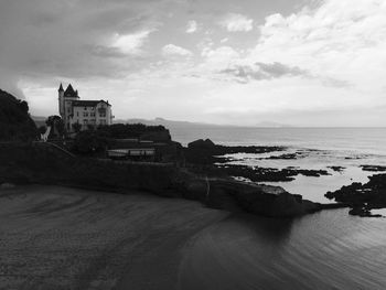 Buildings by sea against sky in city