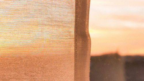 Close-up of curtain against sky during sunset