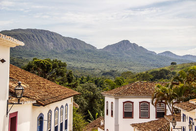 Houses by mountains against sky