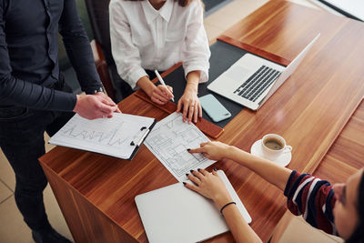 Midsection of business colleagues working on table