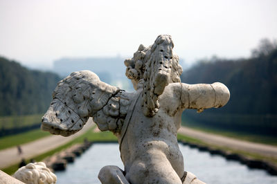 Close-up of angel statue against lake