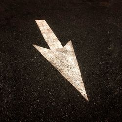 Close-up of arrow sign on road