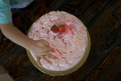 High angle view of hand holding cake