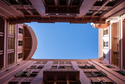 Low angle view of modern building against clear blue sky