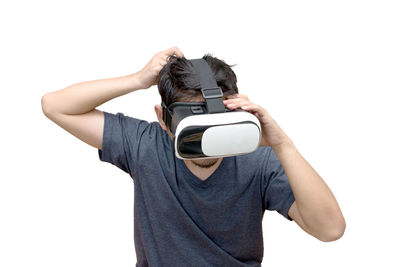 Man holding camera while standing against white background