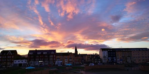 Buildings in city at sunset