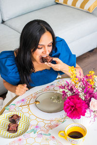 Portrait of young woman sitting on bed at home