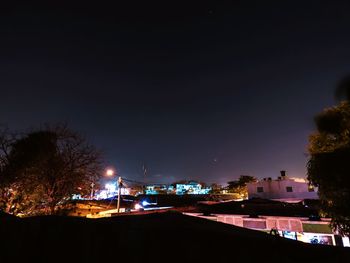 Illuminated buildings against sky at night