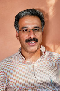 Portrait of man wearing eyeglasses against gray background