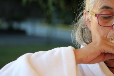 Cropped image of senior woman wearing white bathrobe