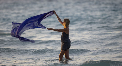 Full length of young woman jumping on beach