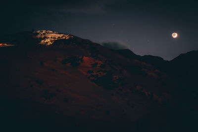 Scenic view of majestic mountains against sky at night