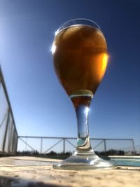 Close-up of beer glass against clear blue sky