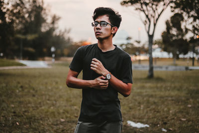 Portrait of young man standing on field