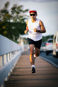 Full length of man jogging on footpath in city