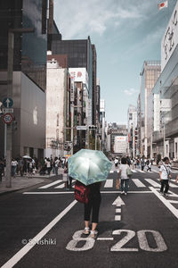 Rear view of people walking on city street