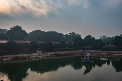 Reflection of man in lake against sky