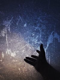 Digital composite image of silhouette hand against sky at night