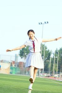 Full length of smiling girl on field