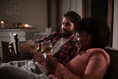Diverse couple with wine having video call