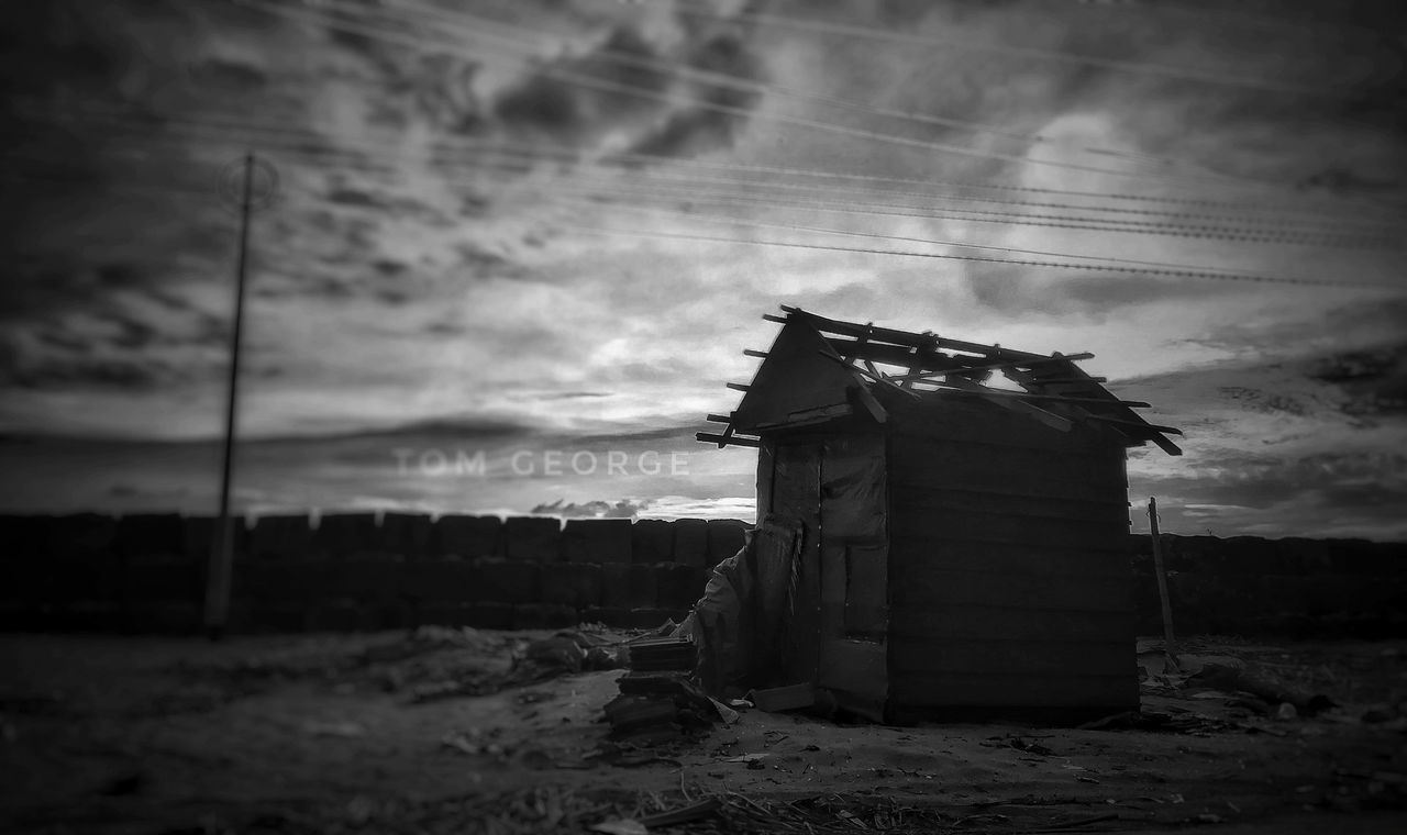 ABANDONED BUILDING BY FIELD AGAINST SKY