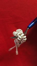 Close-up of figurine on table against red background