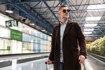 Low angle view of man standing on escalator