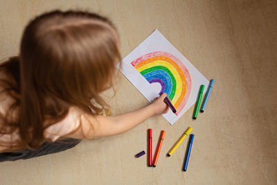 Kid painting rainbow during covid-19 quarantine at home. stay at home social media campaign 