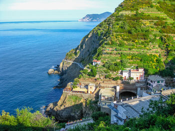 Buildings on green mountain by sea