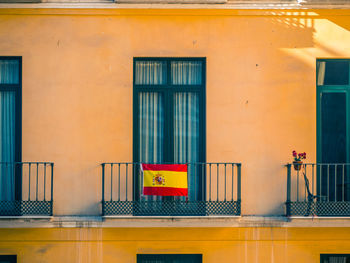 Close view of facade with windows and spanish flags.