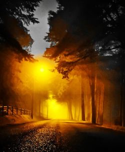 Road amidst trees against sky during sunset